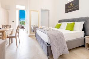 a bedroom with a large bed and a dining table at Almària - Rooms e Garden in Nardò