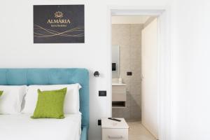 a bedroom with a king sized bed with a blue headboard at Almària - Rooms e Garden in Nardò +121 photos