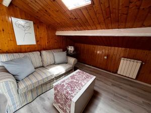 a living room with a couch and a table at Atico de madera Apartamento en Rinlo, RIBADEO in Ribadeo +2 photos