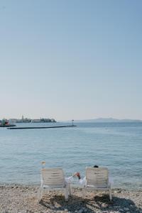 two people laying in chairs on the beach at Hotel Niko in Zadar