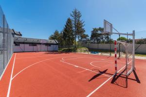 a tennis court with a net on top of it at Flatbook Rodzinne Apartamenty Jantar Resort z Parkingiem, Placem Zabaw i Wiatą Grillową in Jantar