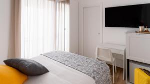 a bedroom with a bed with a desk and a television at Harmonia Rooms by Italy Home Experience in Civitavecchia