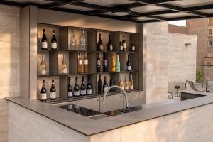 a kitchen with a sink and a shelf of wine bottles at Boutique Hotel OPERA in Rijeka