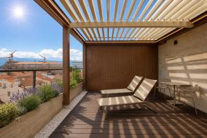 a patio with a pergola and a chair on a balcony at Boutique Hotel OPERA in Rijeka