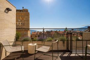 a balcony with chairs and a view of a city at Boutique Hotel OPERA in Rijeka