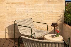 a wicker chair and a table on a patio at Boutique Hotel OPERA in Rijeka +106 photos