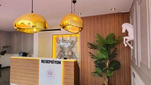 a lobby with two lights and a reception counter at We Nirvana Otel in Mezitli