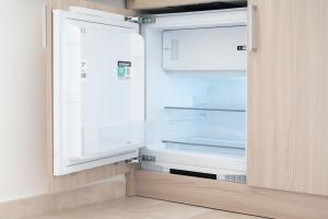 an empty refrigerator with its door open in a kitchen at Monolocale Aurea 5 in Nardò