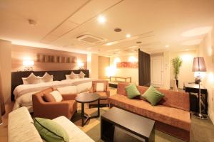 um grande quarto de hotel com uma cama e um sofá em Centurion Hotel Villa Suite Fukui Ekimae em Fukui