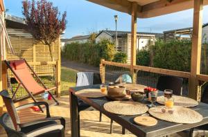 a table with plates of food on a patio at Camping 3 étoiles - Piscine - ccbffbc in Saint-Denis-dʼOléron