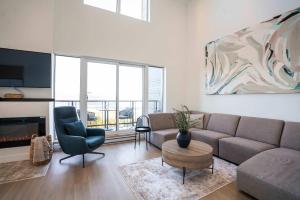 a living room with a couch and a table and chairs at 411 - Luxury Condo - Incredible View & Pool in Baie-Saint-Paul