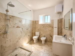 a bathroom with a toilet and a sink at Nova Rooms Velipojë in Velipojë +18 photos