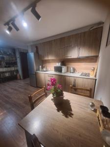 a kitchen with a wooden table with flowers on it at Vaso&Iro hotel in Borjomi