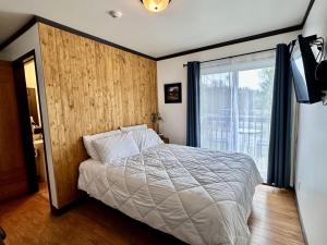 a bedroom with a bed and a large window at Auberge Du Lac Malcom in Sayabec +60 photos