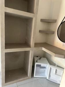 a kitchen with a white refrigerator and shelves at Pousada sonho real in Barreirinhas