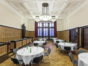 a room with tables and chairs and a chandelier at Mercure Ostrava Center in Ostrava
