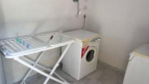 a laundry room with a washing machine and a table at Camping Two Rivers in Shkodër