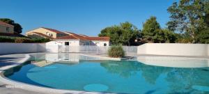 a swimming pool in front of a house at Résidence Lagrange Vacances Le Mas de Torreilles in Torreilles