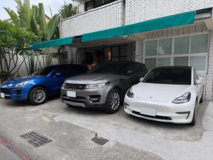 two cars parked in front of a building at 大樹林 Mori Mori 包棟民宿 寵物友善 附車位 in Tainan