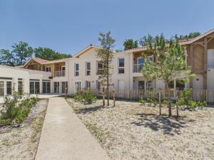 an exterior view of a house with trees in the yard at Le Mid-Length- studio pour 3 - piscine commune in Biscarrosse