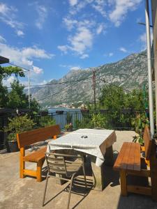 a patio with a table and benches and a mountain at Apartman Jelena in Kotor