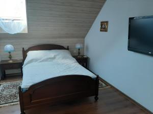 a bedroom with a bed and a flat screen tv at Pod żurawiem II in Szwalk