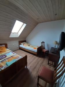 a attic room with two beds and a window at Pod żurawiem II in Szwalk