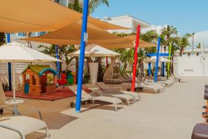 a row of chairs and umbrellas at a resort at Nicholas Color Hotel in Ayia Napa
