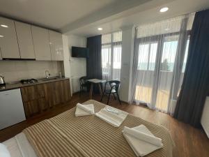 a bedroom with a bed and a kitchen with a table at Mzıurı House 1 in Batumi +46 photos