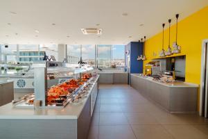 a kitchen with a cafeteria with a lot of food at Nicholas Color Hotel in Ayia Napa