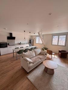 a living room with a couch and a table and a kitchen at Résidence la Plage in La Bourboule