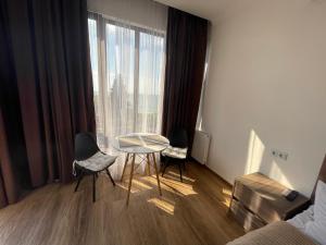 a room with two chairs and a table in front of a window at Mzıurı House 1 in Batumi
