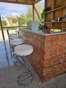 a brick bar with stools lined up against a brick wall at Sunny Breeze Hotel in Vlorë