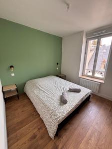 a bedroom with a bed and a green wall at Résidence la Plage in La Bourboule