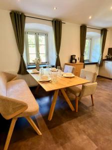 a dining room with a wooden table and chairs at Beim Mühltaler III in Schleching