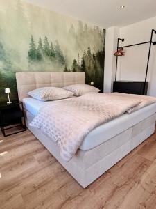 a bedroom with a bed with a painting on the wall at Beim Mühltaler III in Schleching