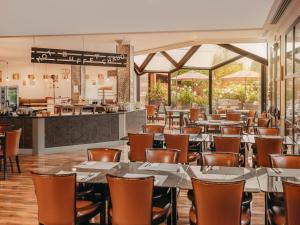 a restaurant with tables and chairs and a counter at Millennium Hotel Paris Charles De Gaulle in Roissy-en-France