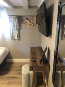 a room with a table and a bed and a tv at Wells House & Gardens Self Catering 3 Bedrooms & Sofa Bed Sleep8 in Glenranny