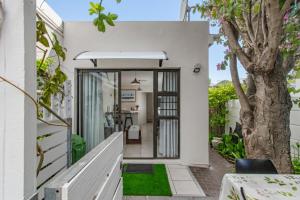 a home entrance with white walls and a tree at Barnacle Tree in Somerset West
