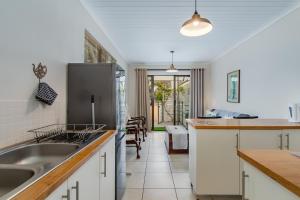 a kitchen with white cabinets and a stainless steel refrigerator at Barnacle Tree in Somerset West