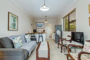a living room with a couch and a table at Barnacle Tree in Somerset West