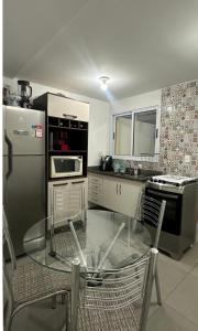 a kitchen with a glass table and chairs in it at Sobrado em volta do lago in Lindóia