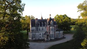 an old castle in the middle of a field at Château de la Redortière in Lézignac-Durand +26 photos