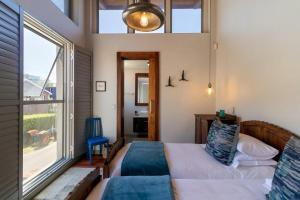 a bedroom with a bed and a large window at Jubilee in Buffelsbaai