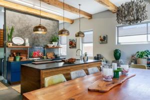a kitchen with a wooden table and a kitchen island at Jubilee in Buffelsbaai +20 photos