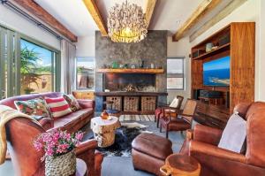a living room with leather furniture and a fireplace at Jubilee in Buffelsbaai