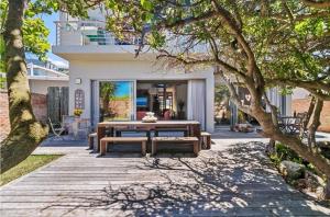 a wooden walkway with a table and benches in front of a house at Jubilee in Buffelsbaai