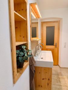 a kitchen with a sink and wooden cabinets at Beim Mühltaler III in Schleching +30 photos