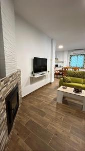 a living room with a fireplace and a tv at Villa Karma in Berja