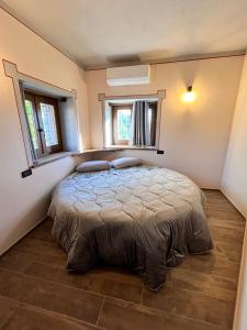 a bedroom with a bed in a room with two windows at Costa Alta - Casa Vacanze in Arcevia